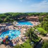 Complesso turistico con piscine, ombrelloni e vegetazione lussureggiante.