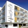 Edificio moderno bianco con balconi e strutture geometriche.