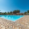 Piscina circondata da una pavimentazione in pietra e sedie a sdraio.