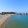 Una spiaggia sabbiosa che si estende lungo una costa, con mare calmo e cielo limpido.