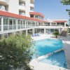 Resort con piscina, balconi e vegetazione circostante.