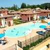 Complesso con piscine, ombrelloni e case intorno, vista aerea.