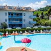 Piscina con giochi colorati e palazzina sullo sfondo.