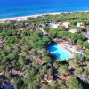 Vista aerea di un complesso con piscina e mare sullo sfondo.